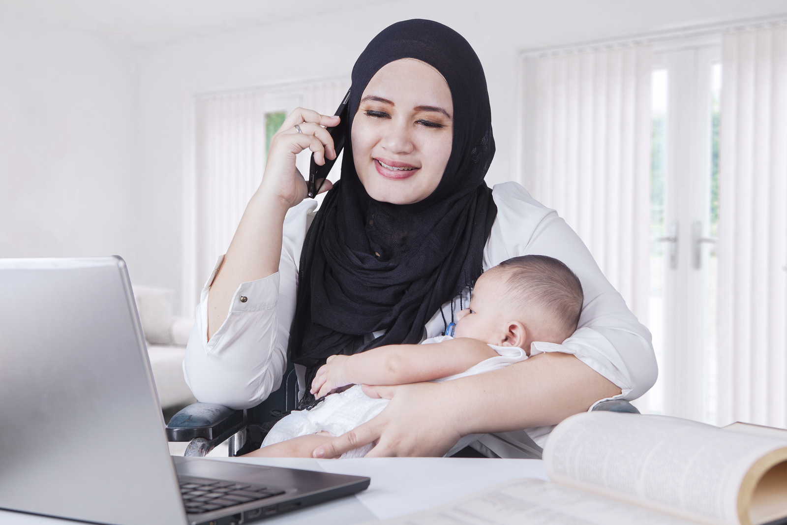 Young Mother Nursing Her Baby While Working